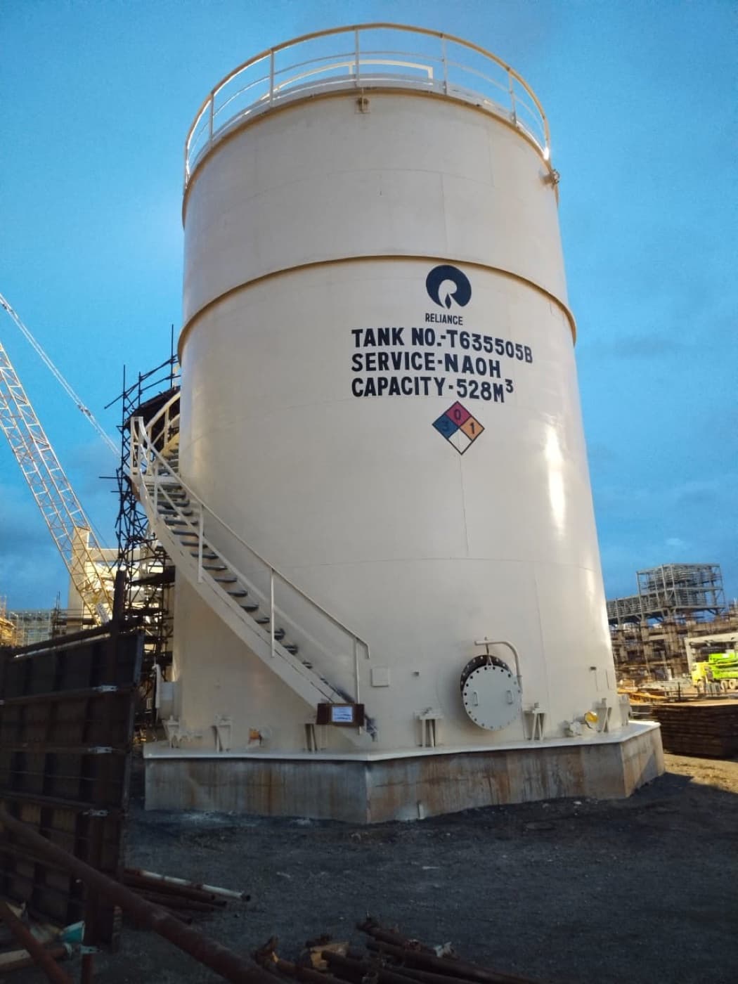 Completed NaOH storage tank (Tank T635505B) for the Reliance polysilicon project, photographed at dusk